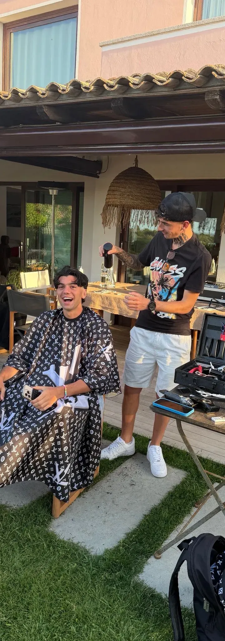 Cliente con mantellina durante il taglio a domicilio in villa, Costa Smeralda