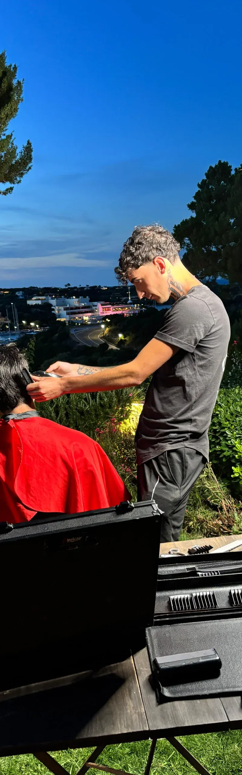 Postazione barber allestita a domicilio: sedia e specchio, taglio in corso in villa